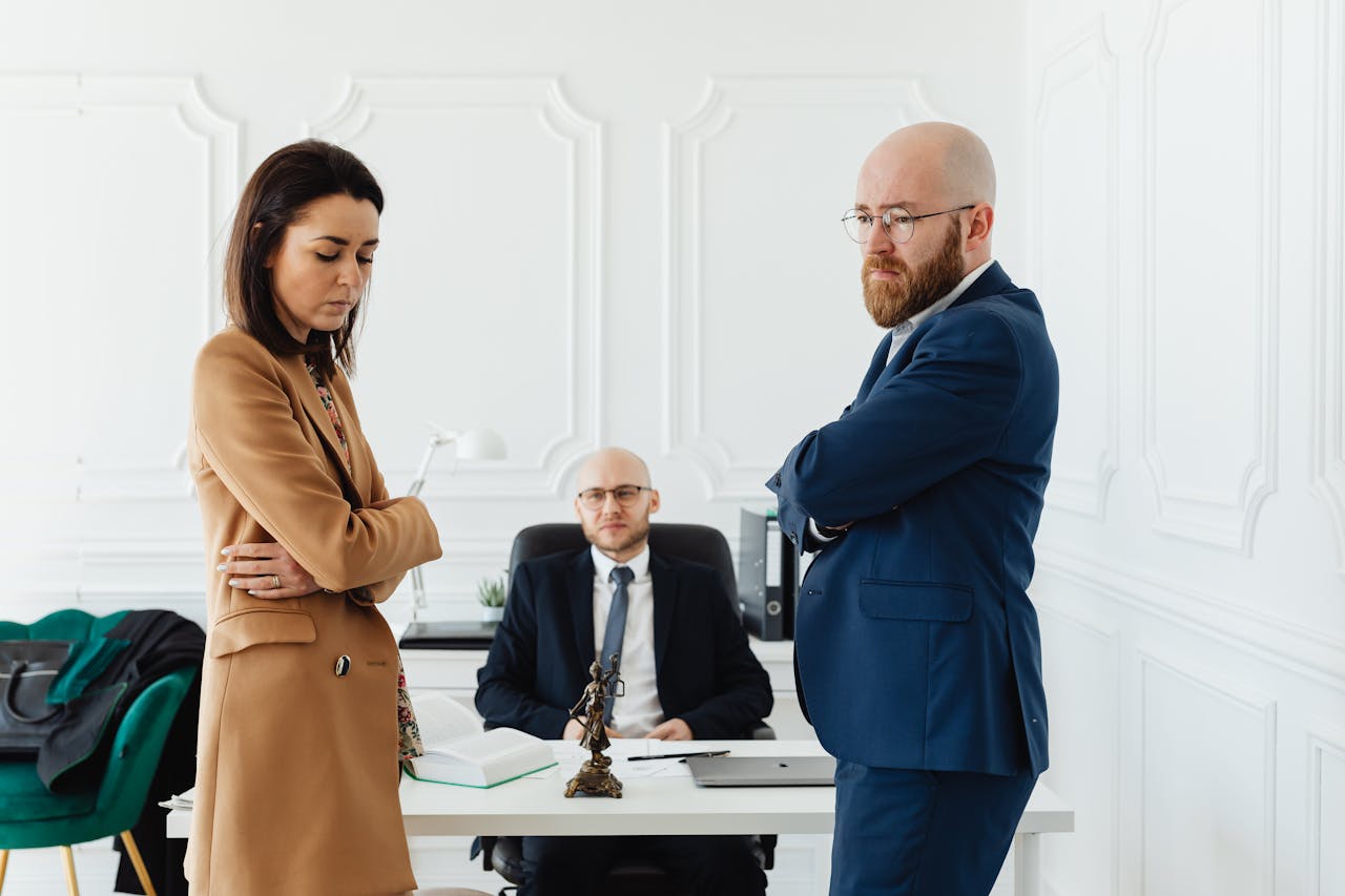 about-01 A couple in corporate attire seeks mediation during a business disagreement in an office setting.