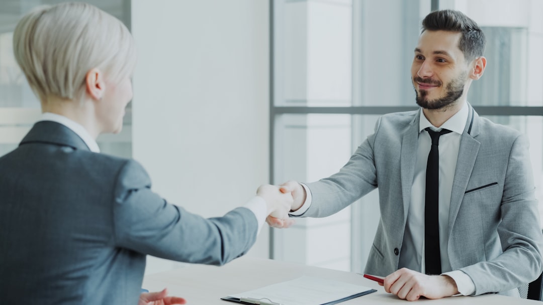 hero-img-01 HR male manager shaking hand to female candidate after having job interview in modern office indoors
